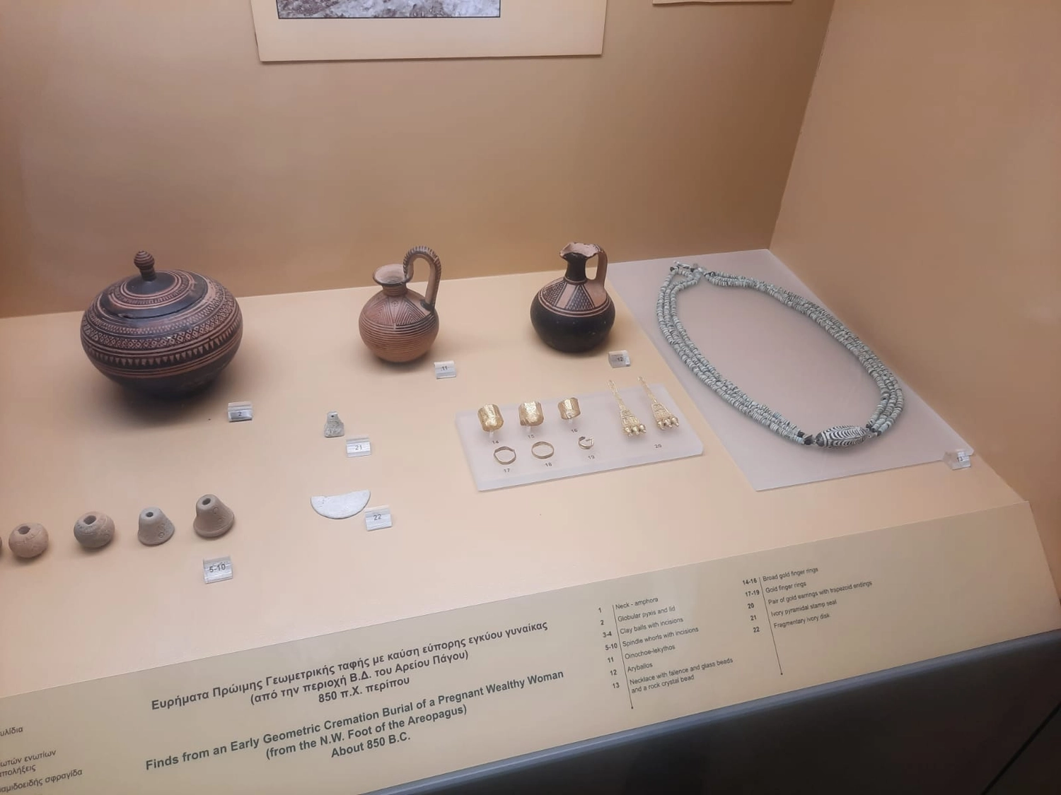 Mbaye Jeng – Companionship Service - Diese Museumsausstellung zeigt Artefakte aus der frühgeometrischen Einäscherungsbestattung einer schwangeren, wohlhabenden Frau, bekannt als das Grab der „Reichen Athenerin“ (datiert auf etwa 850 v. Chr.).