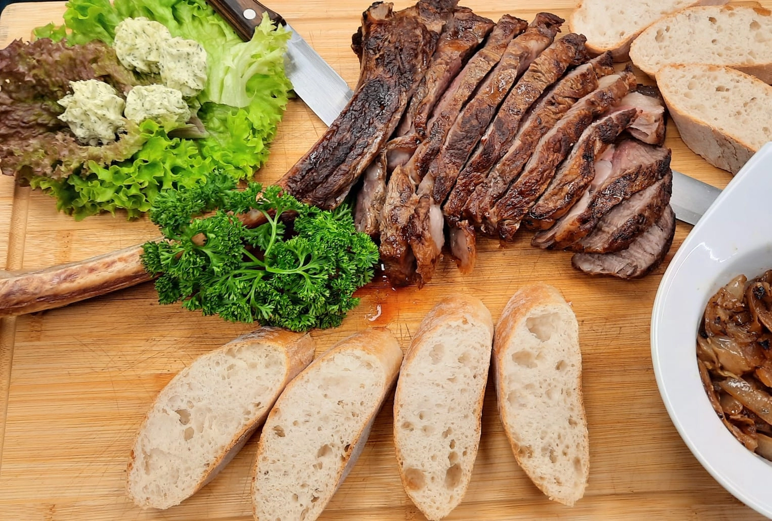 Mbaye Jeng – Companionship Service - Gericht: Das Bild zeigt ein in Scheiben geschnittenes Tomahawk-Steak, erkennbar an seinem charakteristischen langen Knochen.